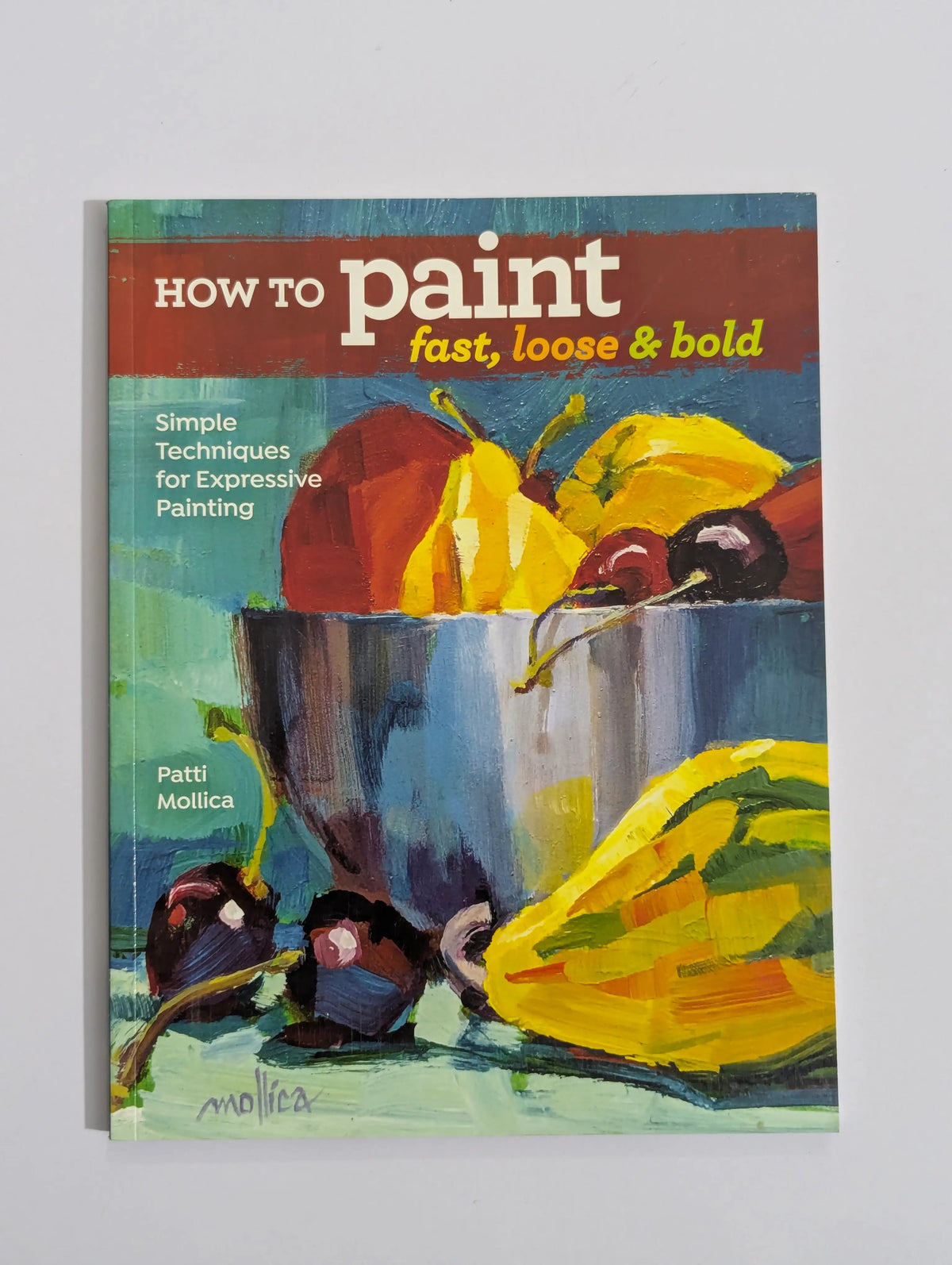 A book titled "How to paint fast, loose & bold" by Patti Mollica, featuring a colorful still life painting of fruit on the cover, photographed against a light gray background.