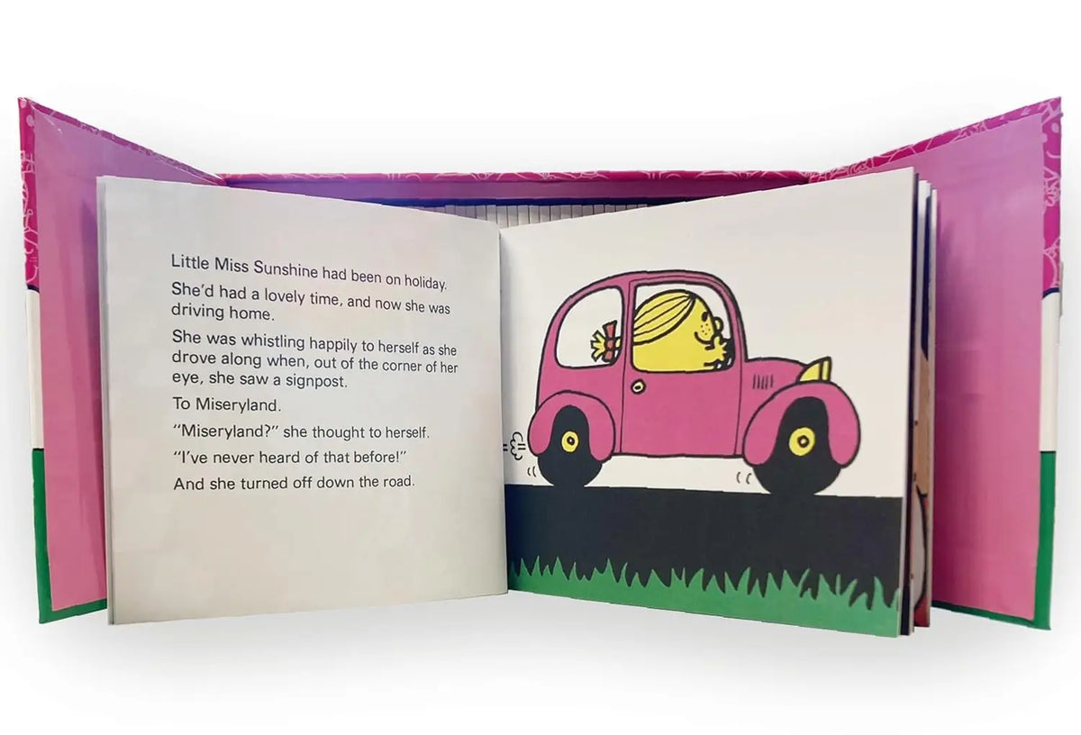 An open children's book with pink cover flaps, showing a printed story page with text on the left and an illustration of a pink car on the right.