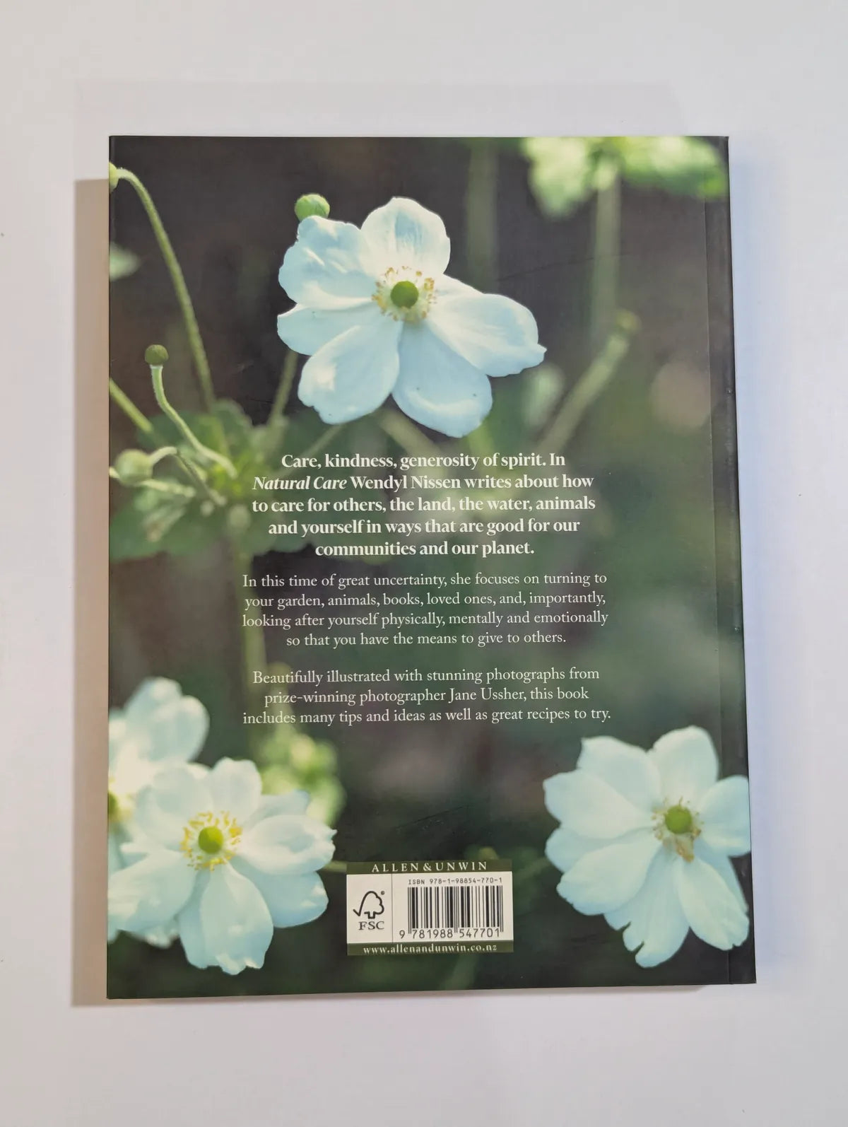 Book cover with white flowers and text on a gray background