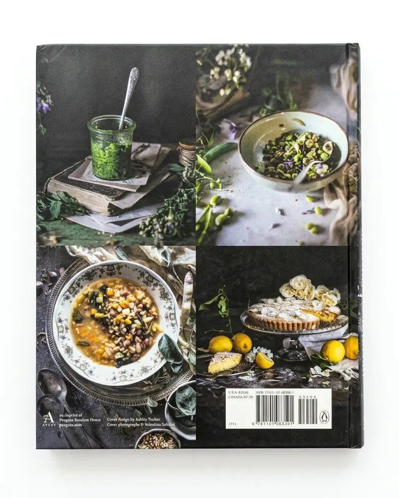 A hardcover cookbook titled 'The Art of Eating' by Aline Lahensie, shown from the back cover against a plain white background. The cover features a four-panel collage of rustic food photography, including a green herb jar, a bowl of salad, a bowl of soup, and a lemon tart.