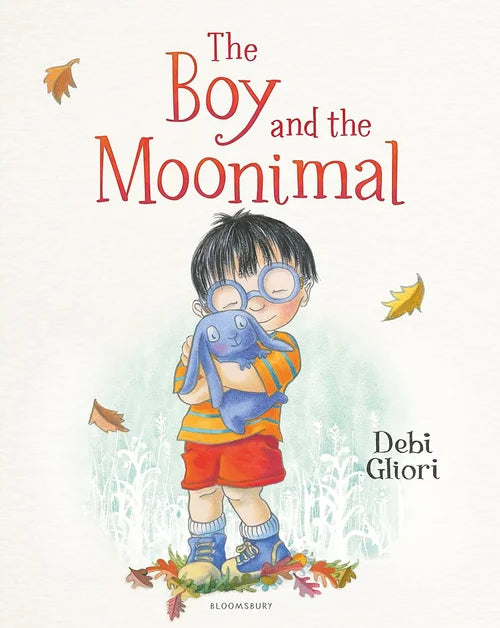 Book cover of 'The Boy and the Moonimal' with a boy holding a blue creature, surrounded by autumn leaves.