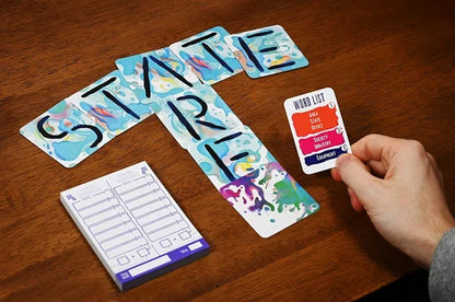 Card game with colorful cards and a hand holding a card on a wooden table