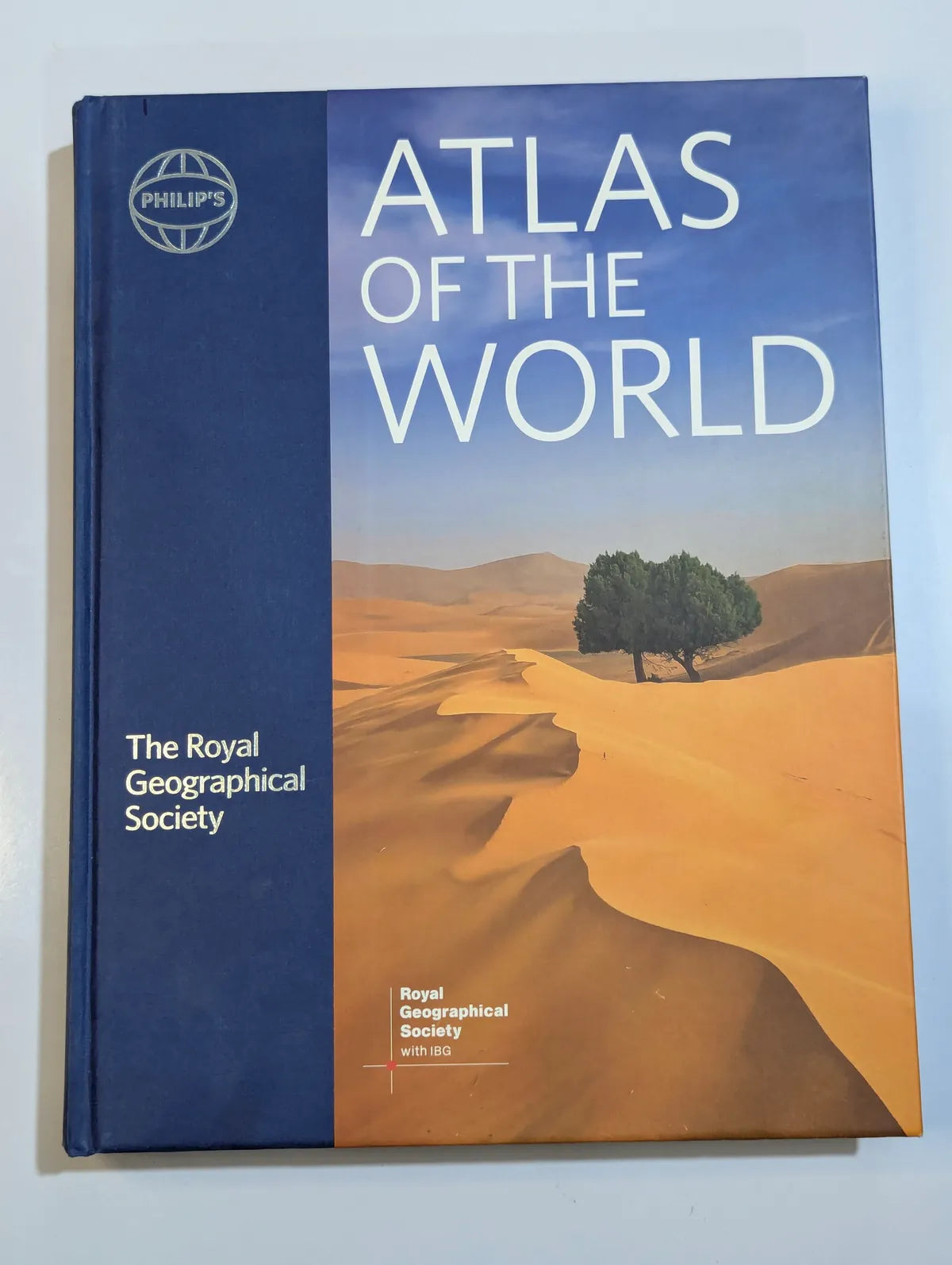 Atlas of the World by The Royal Geographical Society on a light blue background