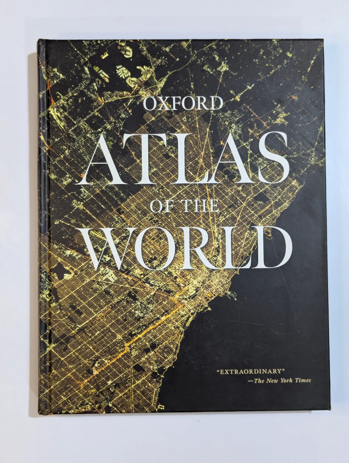 Book titled 'Oxford Atlas of the World' with map design on cover