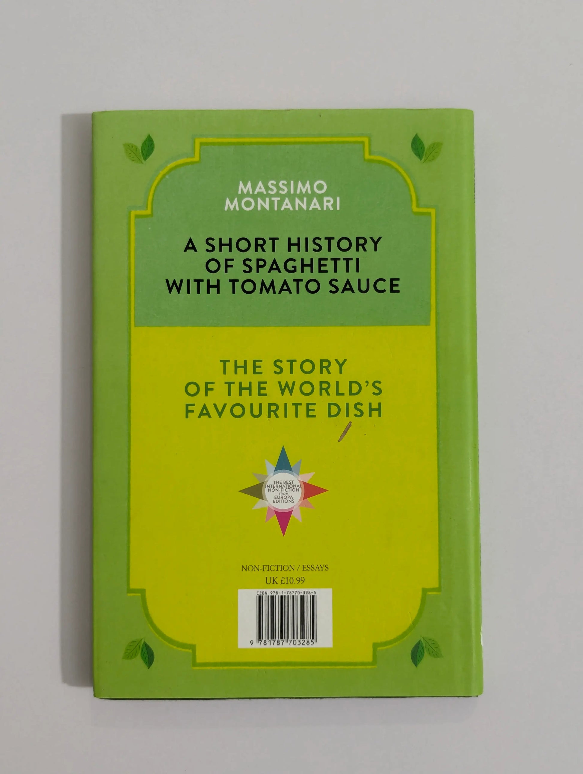A book titled 'A Short History of Spaghetti with Tomato Sauce' by Massimo Montanari, featuring a bright lime green cover with a yellow central panel and black text.