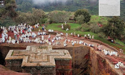 Group of people in white robes at a religious site with stone architecture.