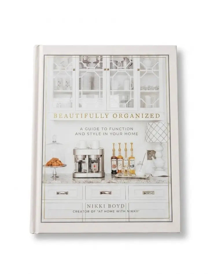 A hardcover book titled 'Beautifully Organized' by Nikki Boyd, featuring a white and gray kitchen-themed cover illustration with gold lettering, shown on a clean white background.