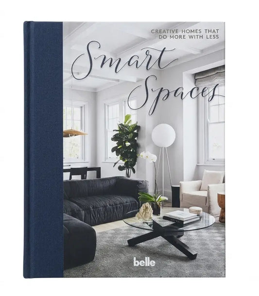 A hardcover book titled "Smart Spaces" with a navy blue spine and cover, featuring a modern living room interior photograph on the front. The book is photographed upright against a plain white background.