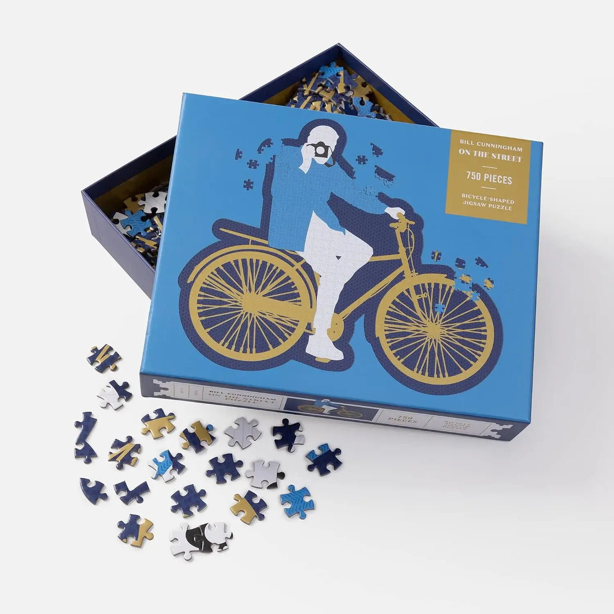 Jigsaw puzzle with pieces scattered, featuring a design of a person on a bicycle, in a blue box.