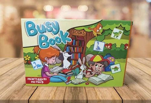 Box of 'Busy Book' with illustrations of children and animals on a wooden surface.
