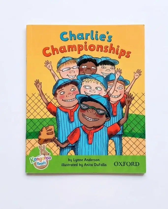 Children's book titled 'Charlie's Championships' by Lynne Anderson, illustrated by Anita DuFallo, published by Oxford. The cover features a colorful cartoon illustration of a group of children in blue and orange baseball uniforms celebrating on a field.