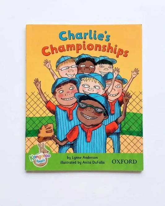 Children's book titled 'Charlie's Championships' by Lynne Anderson, illustrated by Anita DuFallo, published by Oxford. The cover features a colorful cartoon illustration of a group of children in blue and orange baseball uniforms celebrating on a field.