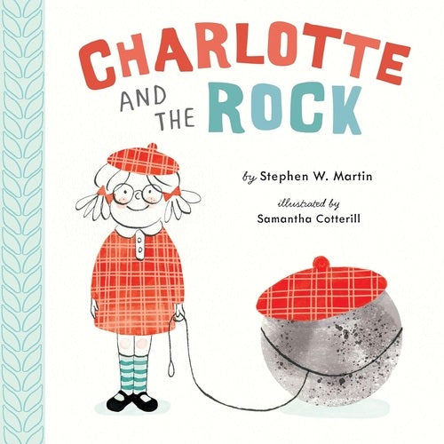 Book cover of 'Charlotte and the Rock' with a character in a red outfit and hat, holding a rock.
