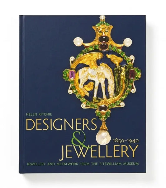 The book cover of 'Designers & Jewellery 1850-1940' by Helen Ritchie, featuring a dark navy blue background with a large gold, green, and white jeweled emblem in the center.