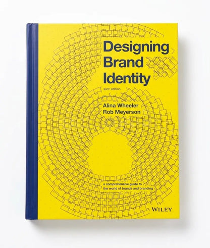 A hardcover book titled "Designing Brand Identity" by Alina Wheeler and Rob Meyerson, published by Wiley. The cover is bright yellow with a black circular grid pattern and dark blue spine, shown on a clean white background.