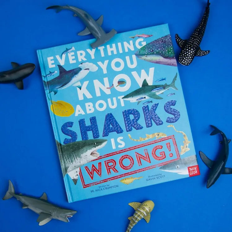 Book titled 'Everything You Know About Sharks Is Wrong' on a blue background with shark figurines.