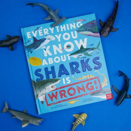 Book titled 'Everything You Know About Sharks Is Wrong' on a blue background with shark figurines.