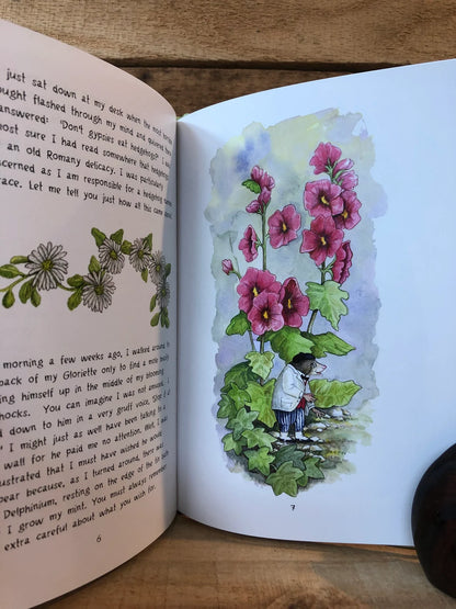 Open book with a colorful illustration of flowers and a person on a wooden surface