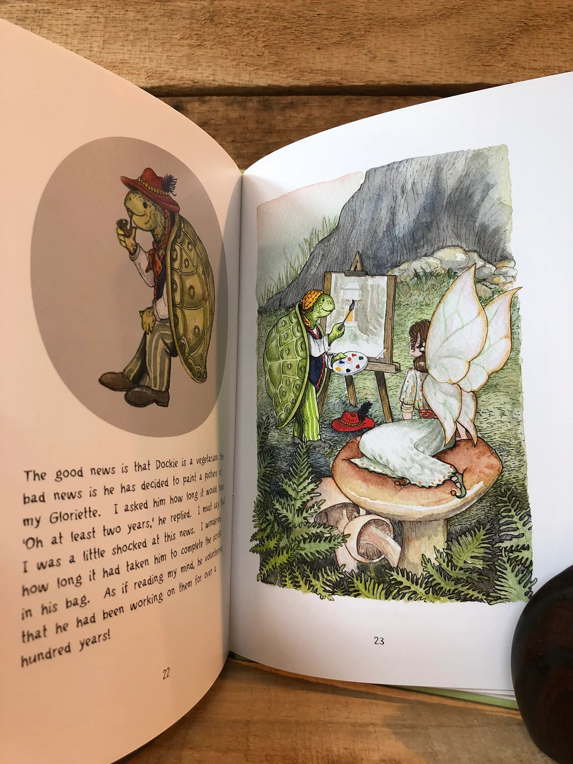 Open book with illustrated fairy tale scene on a wooden surface