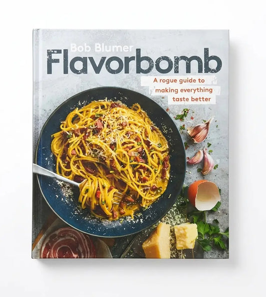 The book 'Flavorbomb' by Bob Blumer, featuring a cover with a photo of spaghetti carbonara in a dark bowl, set against a light gray textured background.