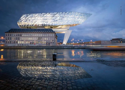 Modern building with a unique design near a waterfront at night.