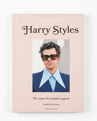 A hardcover book titled 'Icons of Style Harry Styles' by Lauren Cochrane, featuring a pale pink cover with a central portrait of Harry Styles in sunglasses, a blue suit, and a light blue shirt.