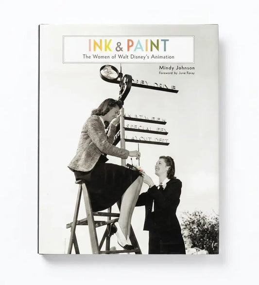 A hardcover book titled 'Ink & Paint: The Women of Walt Disney's Animation' by Mindy Johnson, featuring a black-and-white cover photo of two women working on a signpost, shown against a plain white background.