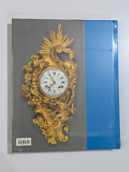 Decorative clock design on a book cover with gold detailing and a white face.