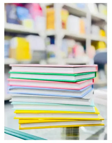 Stack of colorful books with a blurred bookshelf in the background