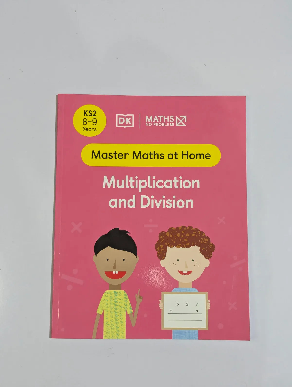 Book titled 'Master Maths at Home: Multiplication and Division' on a gray background