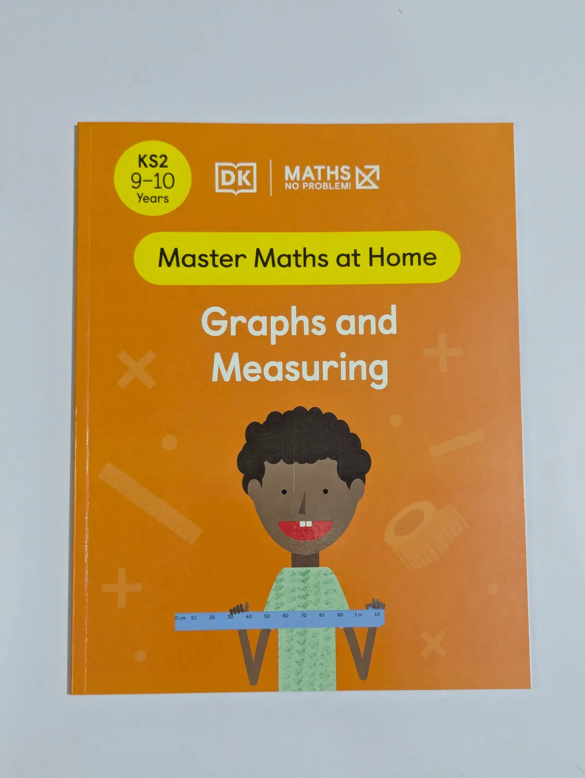 Book titled 'Master Maths at Home: Graphs and Measuring' by DK on an orange background