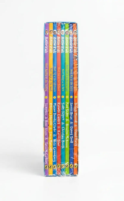 A set of children's books standing upright in a row, showing colorful spines with titles including 'Aussie Kids' and 'The Power of Positive Thinking,' photographed on a light gray background.