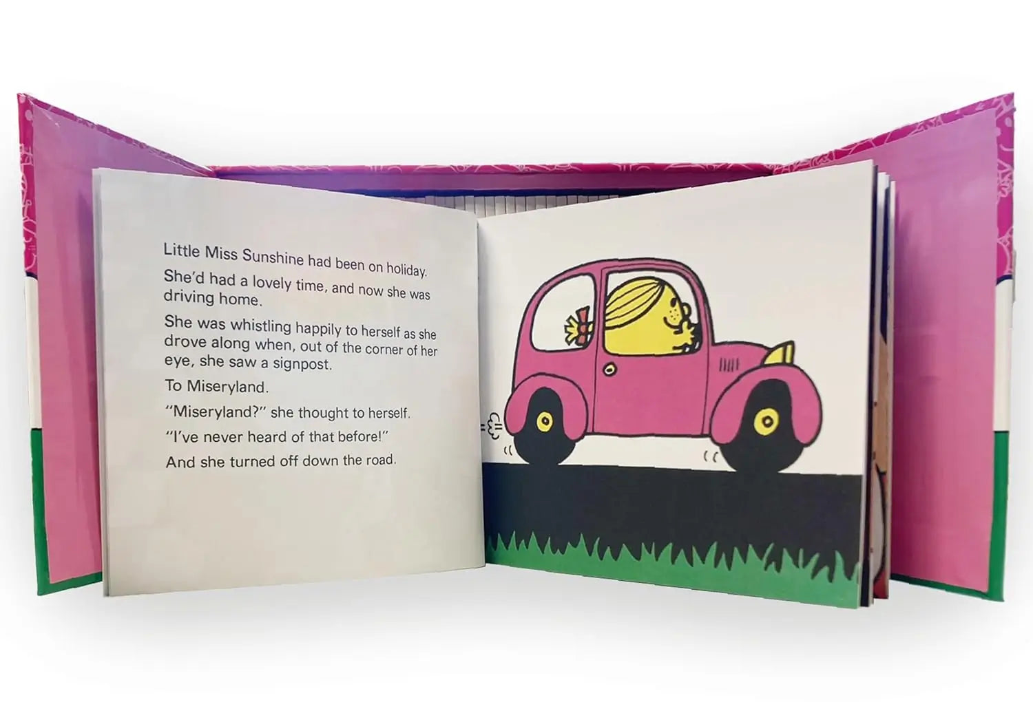 An open children's book with pink cover flaps, showing a printed story page with text on the left and an illustration of a pink car on the right.