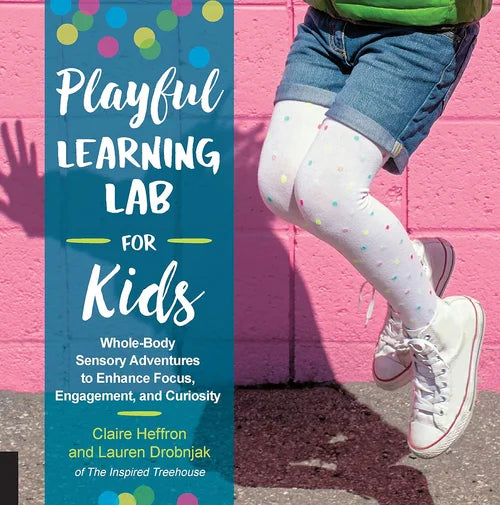 Book titled 'Playful Learning Lab for Kids' with a child's legs wearing colorful tights and white sneakers against a pink wall.