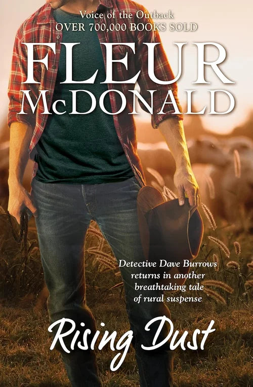 Book cover of 'Rising Dust' by Fleur McDonald with a person holding a hat in a field.
