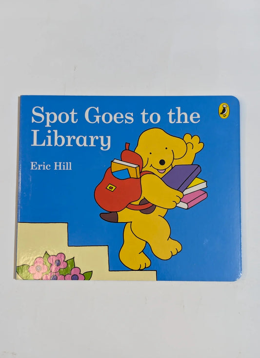 Book cover of 'Spot Goes to the Library' by Eric Hill with a cartoon dog holding books against a blue background.