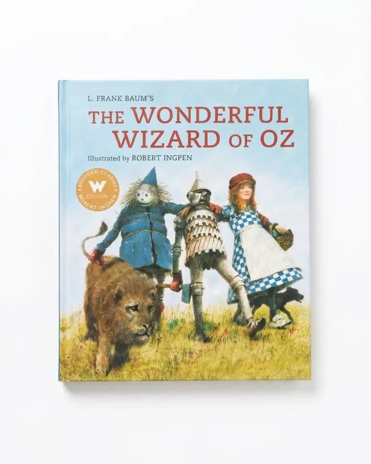 The Wonderful Wizard of Oz hardcover book by L. Frank Baum, illustrated by Robert Ingpen, featuring a light blue sky background and colorful character artwork on the cover.