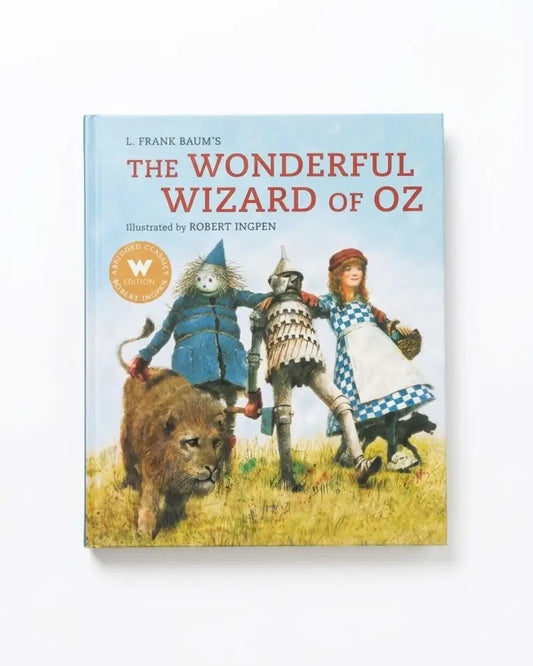The Wonderful Wizard of Oz hardcover book by L. Frank Baum, illustrated by Robert Ingpen, featuring a light blue sky background and colorful character artwork on the cover.
