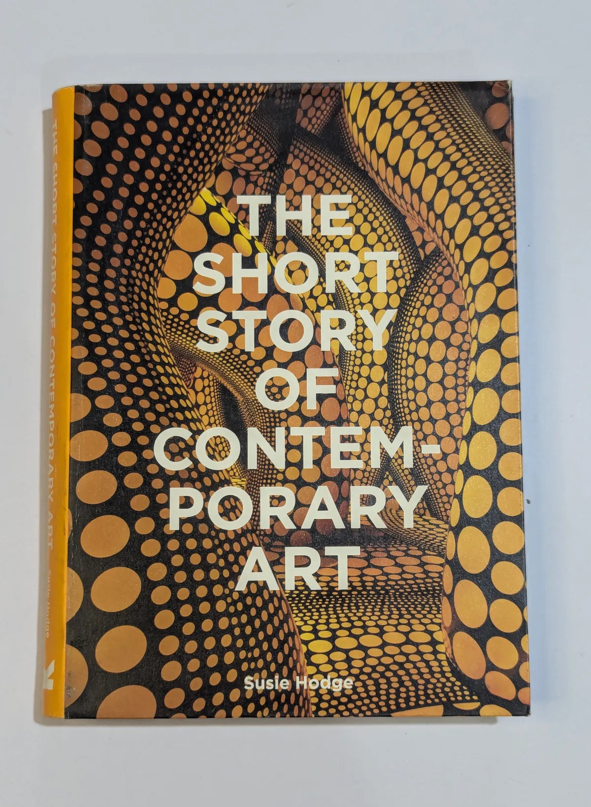 Book titled 'The Short Story of Contemporary Art' with a patterned cover on a light gray background