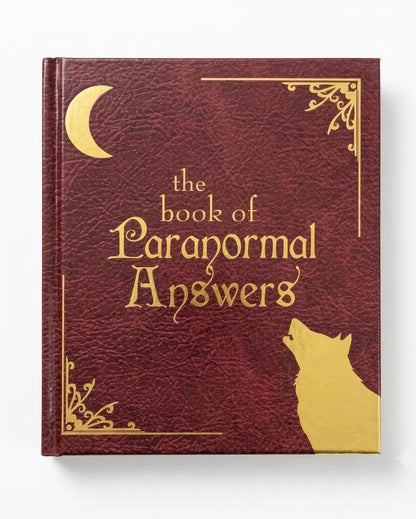 A hardcover book titled 'the book of Paranormal Answers' with a textured dark red cover and gold foil details, including a crescent moon, decorative corner flourishes, and a wolf silhouette, shown on a white background.