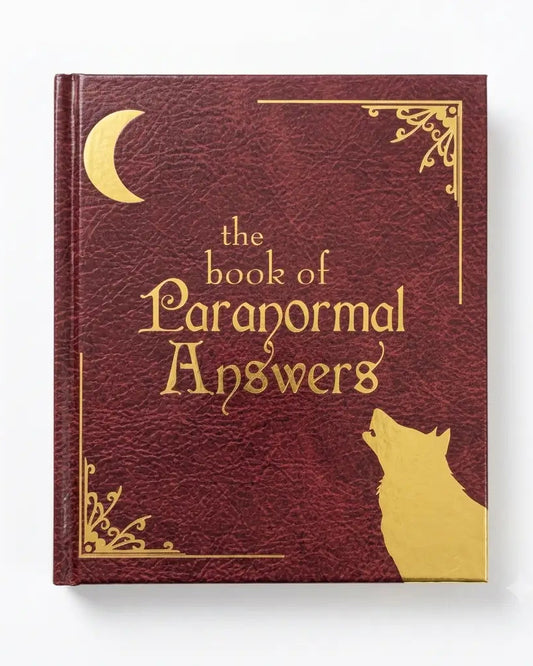 A hardcover book titled 'the book of Paranormal Answers' with a textured dark red cover and gold foil details, including a crescent moon, decorative corner flourishes, and a wolf silhouette, shown on a white background.