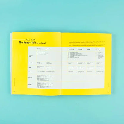 Open book with a meal plan on a teal background