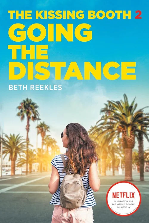 Book cover of 'The Kissing Booth 2: Going the Distance' with a person walking on a palm tree-lined street.