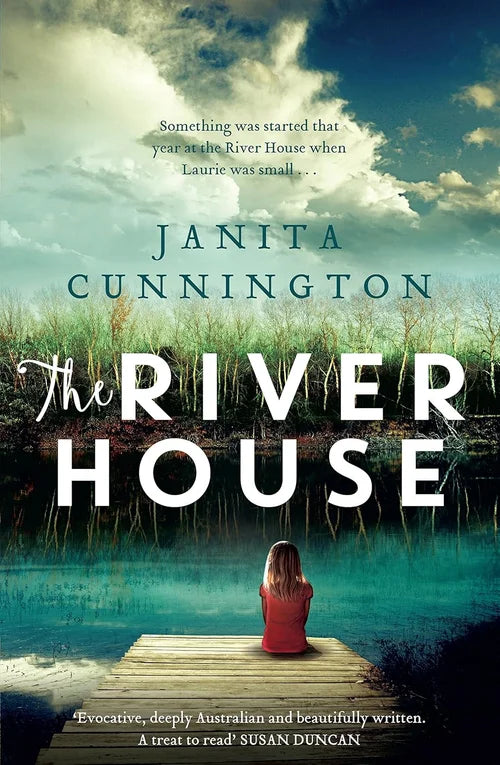 Book cover of 'The River House' by Janita Cunnington with a woman sitting on a dock over a river.