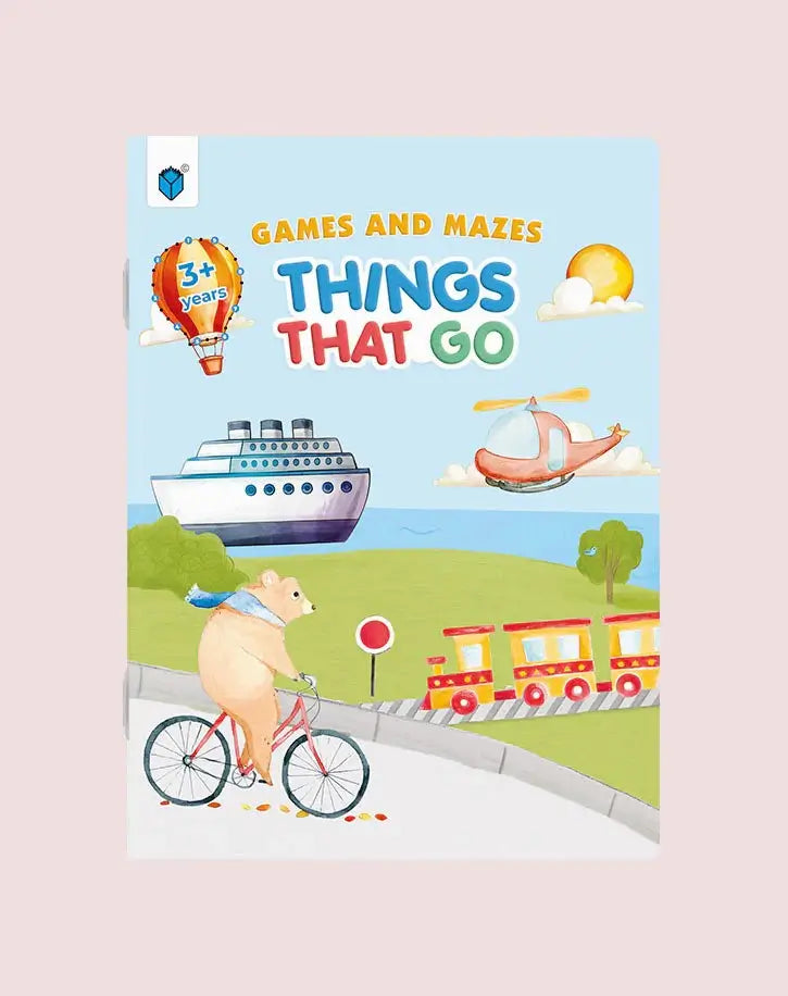Children's activity book cover titled 'Games and Mazes Things That Go' featuring a playful illustrated scene with a pig riding a bicycle, a hot air balloon, a cruise ship, a helicopter, and a train on a light pink background.