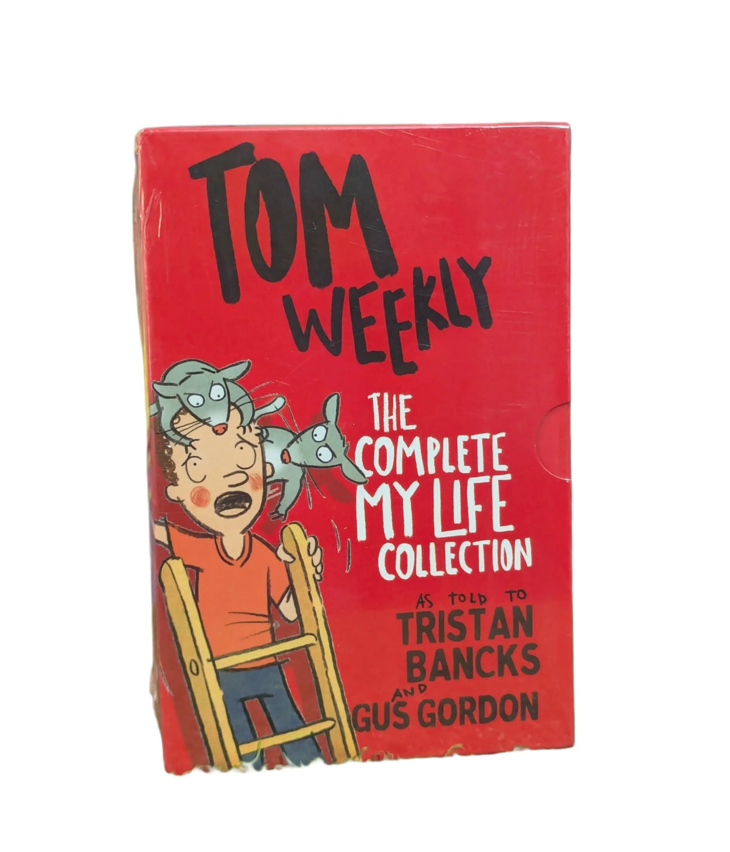 A vintage-style red book cover for 'Tom Weekly: The Complete My Life Collection' featuring cartoon artwork of a boy in an orange shirt and blue pants sitting in a chair with a gray creature on his head, with text crediting Tristan Bancks and Gus Gordon.