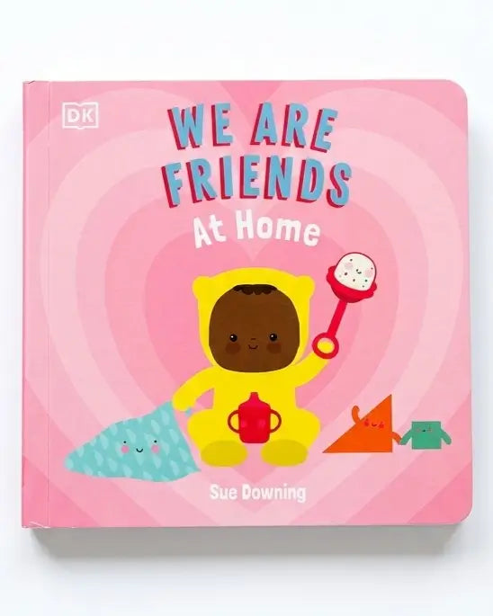 DK children's board book titled 'We Are Friends At Home' by Sue Downing, featuring a pink cover with a cartoon child in a yellow hood holding a red teapot and rattle.