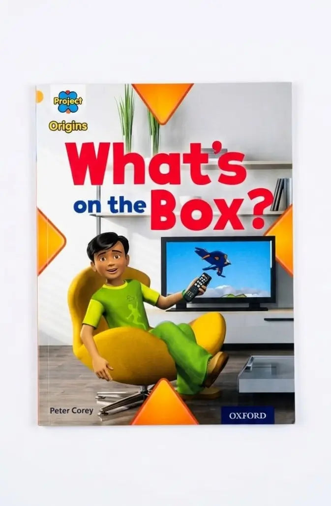 Front cover of the children's book 'What's on the Box?' by Peter Corey, published by Oxford. The cover features a colorful illustration of a boy in a green shirt sitting in a yellow chair and holding a TV remote, with a television screen showing a bird.